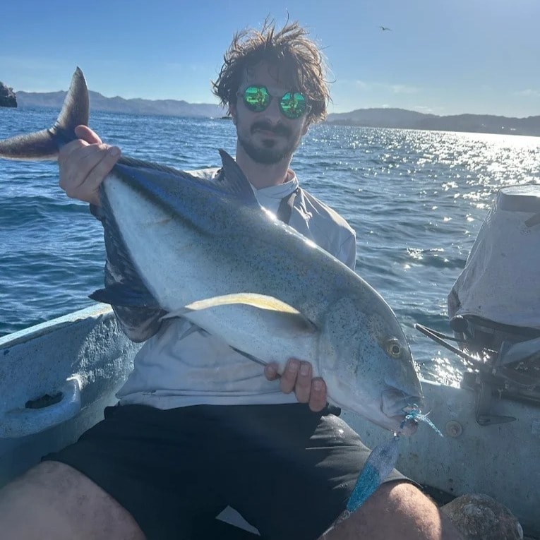 Guest holding a large jack on the boat
